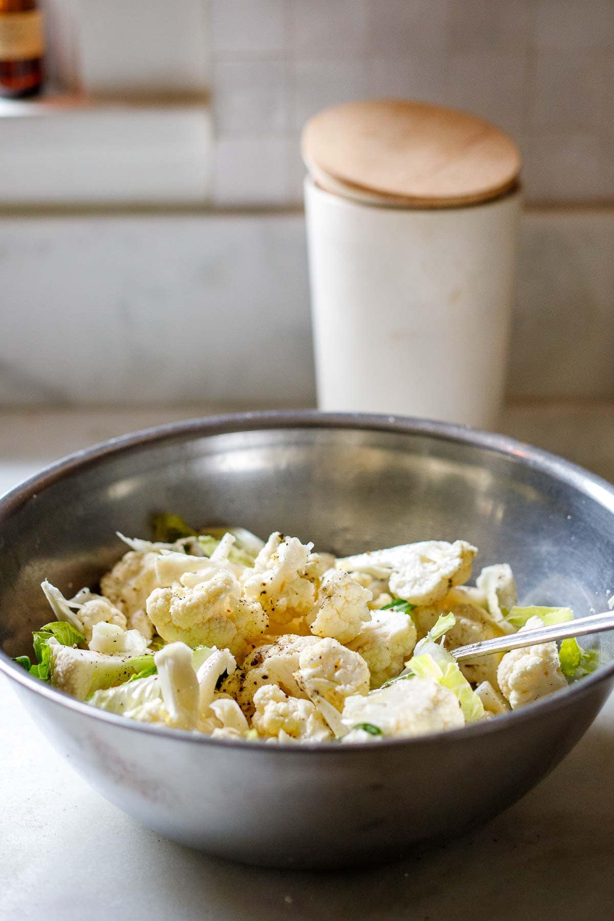 tossing the cauliflower in a large bowl. 