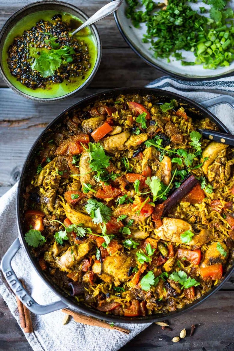 An authentic & insanely delicious recipe for Chicken Biryani with Cilantro Yogurt Sauce. | www.feastingathome.com #chickenbiryani #indianrice #indianchicken