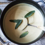 Creamy Cauliflower Soup with garlic and sage, topped with an optional pine nut"crumble" - healthy, quick and easy, perfect for weeknights when time is short. | #cauliflowersoup www.feastingathome.com