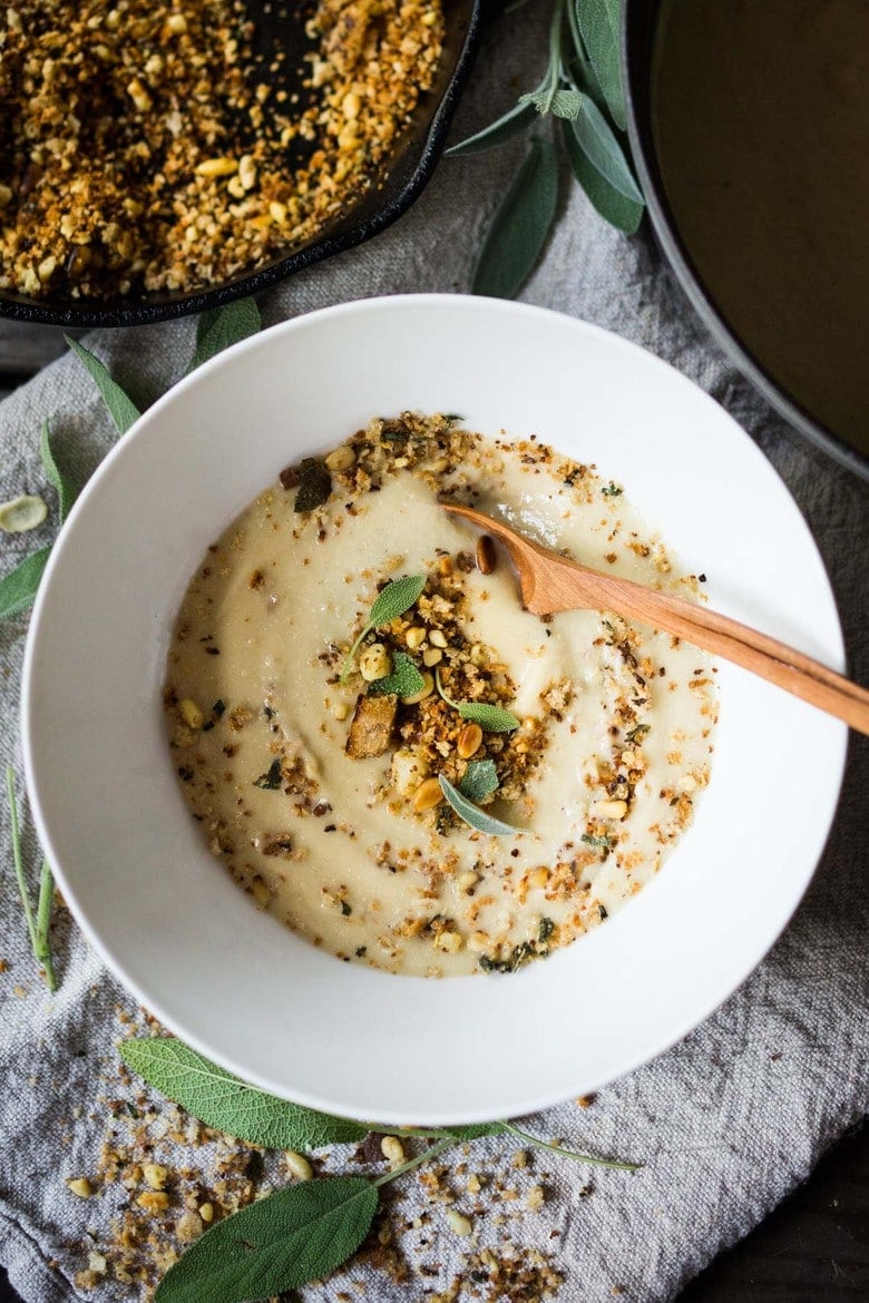 Creamy Cauliflower Soup with garlic and sage, topped with an optional pine nut"crumble" - healthy, quick and easy, perfect for weeknights when time is short. | #cauliflowersoup www.feastingathome.com