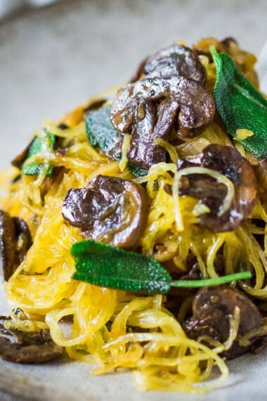 This delicious spaghetti squash recipe is made with a baked spaghetti squash, savory mushrooms, garlic, and sage-a flavorful, healthy vegetarian dinner! It's a low-carb, gluten-free meal that feels like a comforting pasta dish, perfect for fall. Keep it vegan or add pecorino cheese.
