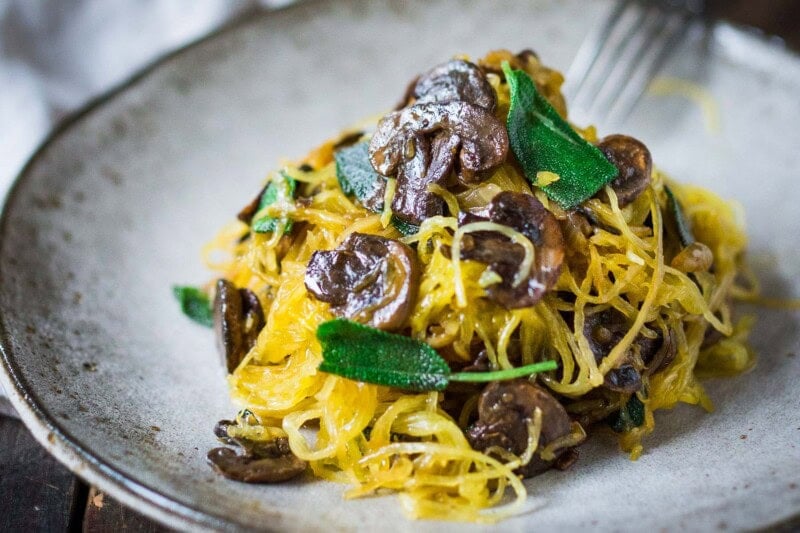 This delicious spaghetti squash recipe is made with a baked spaghetti squash, savory mushrooms, garlic, and sage-a flavorful, healthy vegetarian dinner! It's a low-carb, gluten-free meal that feels like a comforting pasta dish, perfect for fall. Keep it vegan or add pecorino cheese.