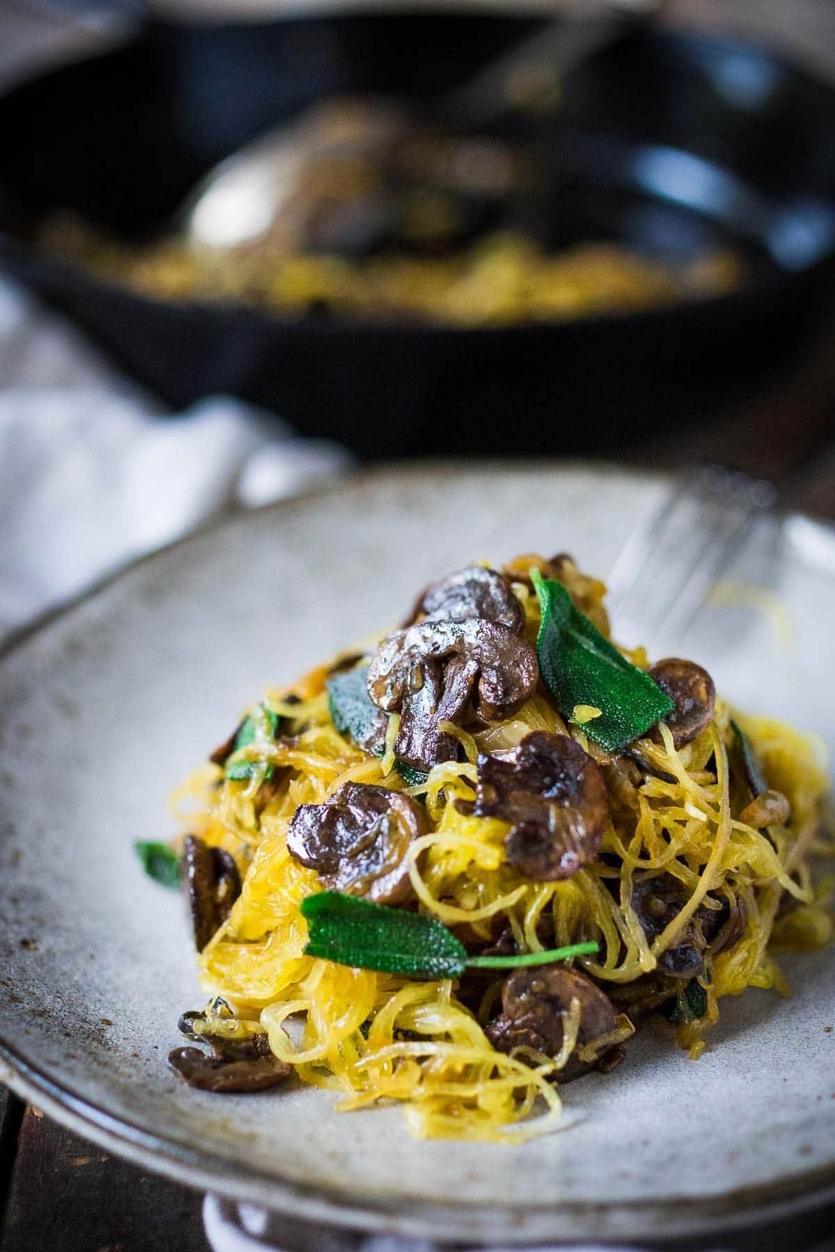 Roasted Spaghetti Squash with Mushrooms, garlic, and sage is a flavorful, healthy vegetarian dinner! This is a low-carb, gluten-free meal that feels like a comforting pasta dish, perfect for fall! Keep it vegan or add pecorino cheese. 