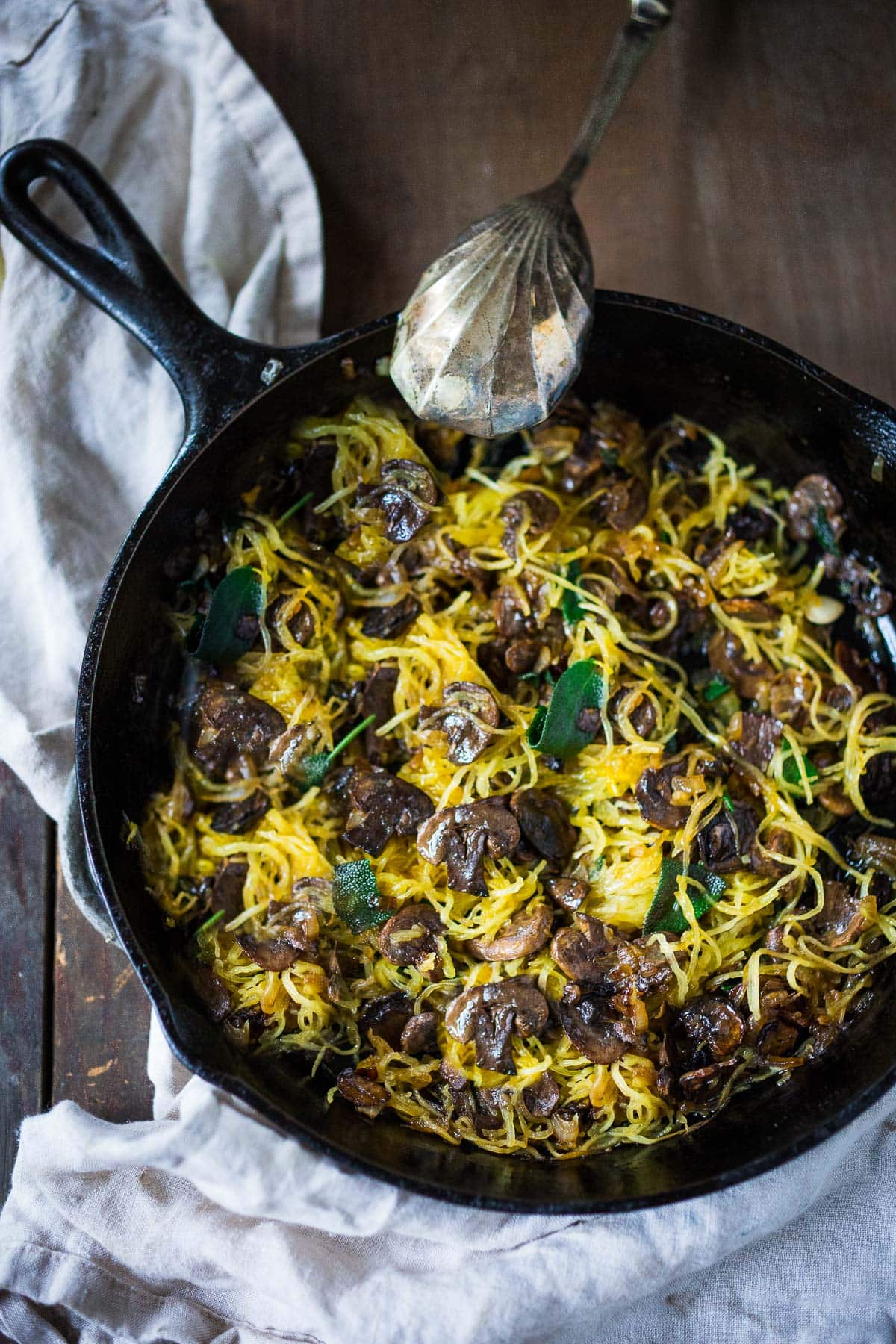 Sauteed mushrooms with spaghetti squash in a skillet.