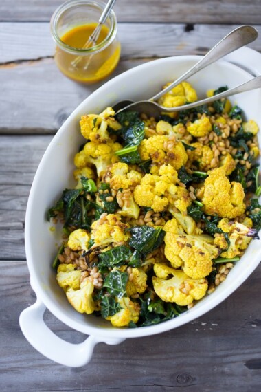 Roasted Cauliflower Farro Salad with lacinato kale and an earthy turmeric dressing. Delicious and healthy, it can be a served warm as a fall side dish, or chilled as a salad| www.feastingathom.com
