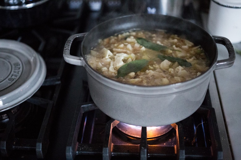 A simple delicious recipe for Velvety Cauliflower Leek Soup with Sage & Toasted Pine Nut Crumble | www.feastingathome.com