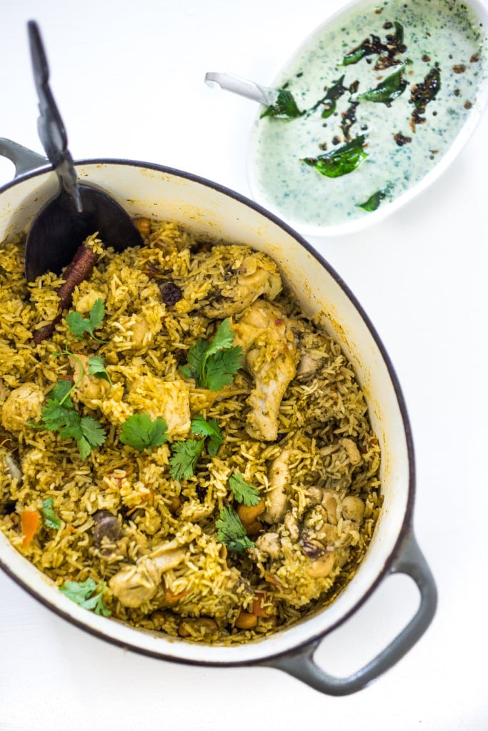 An authentic & insanely delicious recipe for Chicken Biryani with Cilantro Yogurt Sauce. Vegetarian option included as well as detailed step by step instructions. | www.feastingathome.com