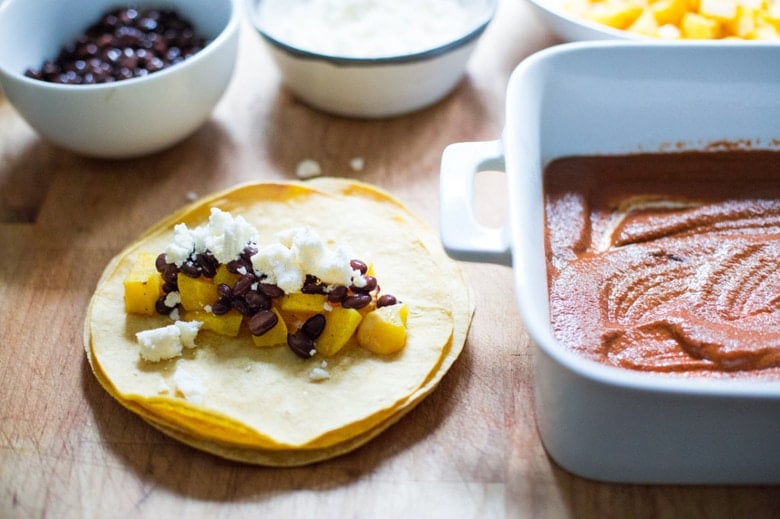 Roasted Butternut Mole Enchiladas with Blackbeans - topped with cilantro, avocado and toasted sesame and pumpkin seeds. An easy delicious vegetarian main. | www.feastingathome.com