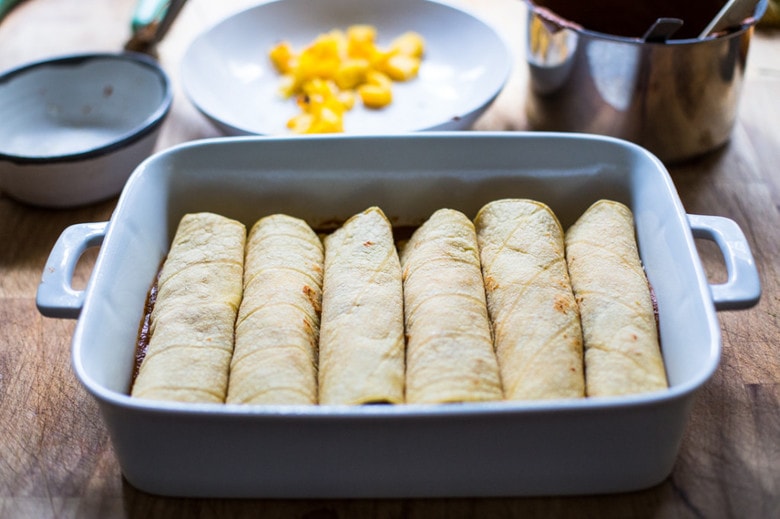 Roasted Butternut Mole Enchiladas with Blackbeans - topped with cilantro, avocado and toasted sesame and pumpkin seeds. An easy delicious vegetarian main. | www.feastingathome.com