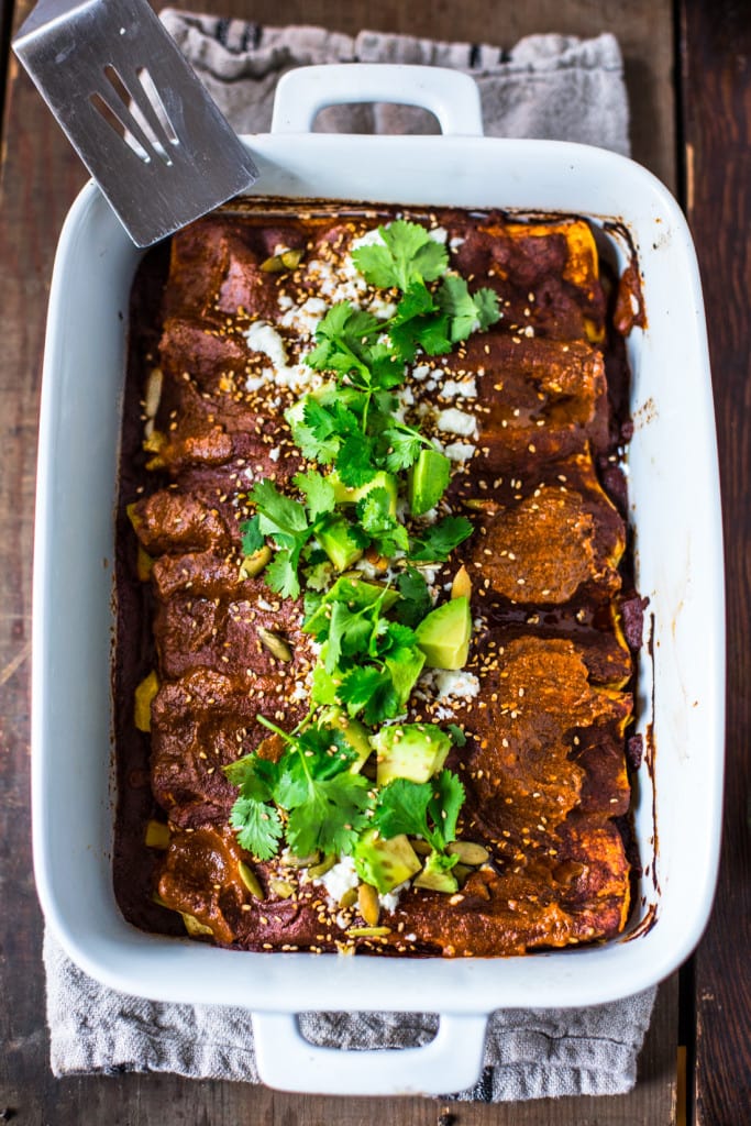 Roasted Butternut Enchiladas with Quick Mole Sauce - topped with cilantro, avocado and toasted sesame and pumpkin seeds. An easy delicious vegetarian main. | #mole #molesauce #enchiladas #vegetarian #butternut #butternutenchiladas #fall recipes www.feastingathome.com