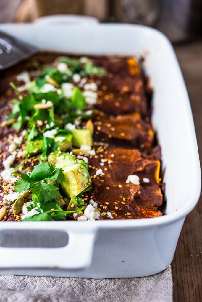 Roasted Butternut Mole Enchiladas with Blackbeans - topped with cilantro, avocado and toasted sesame and pumpkin seeds. An easy delicious vegetarian main.Vegan-adaptable! | www.feastingathome.com