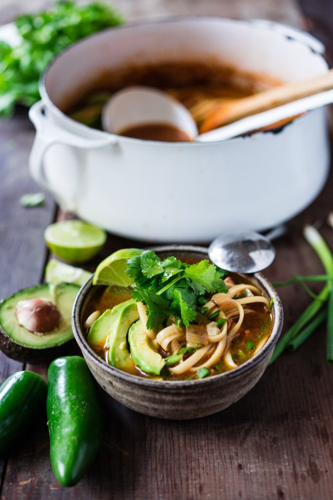 Soup topped with avocado and cilantro in a bow with a spoon. 