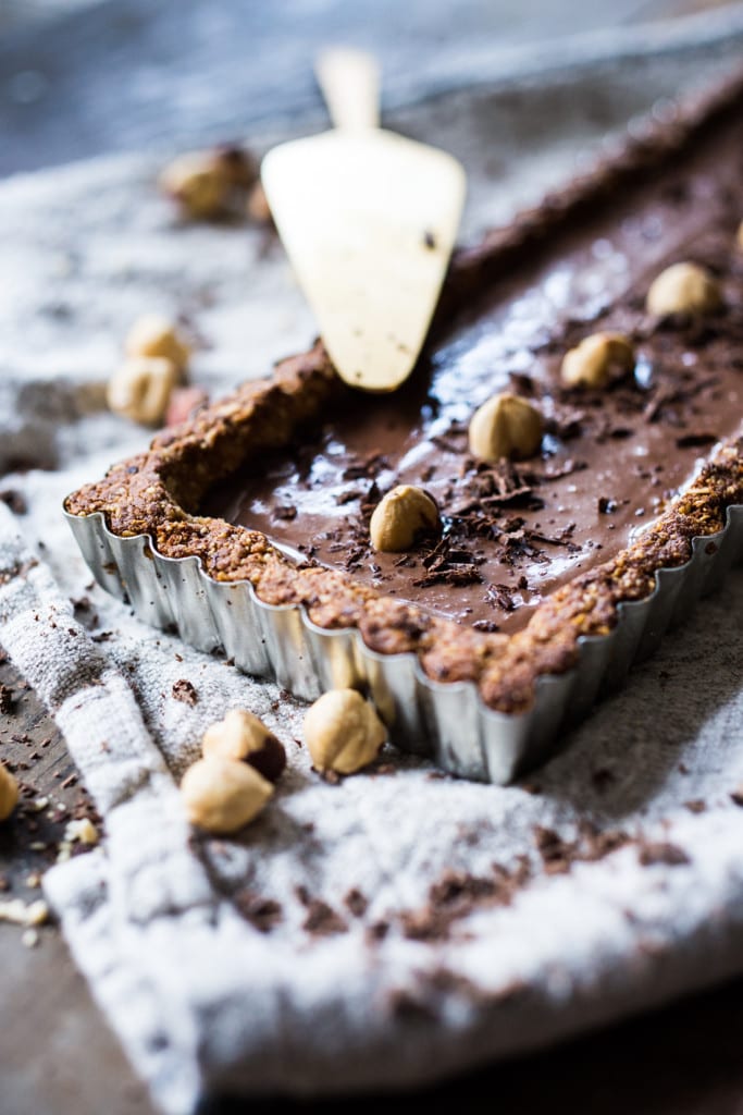 Vegan Chocolate Tart with Hazelnut Crust- a vegan and gluten-free tart that is deceptively decadent, silky smooth and luscious! | #vegantart #vegandessert #glutenfreedessert #hazelnuts #chololatetart www.feastingathome.com