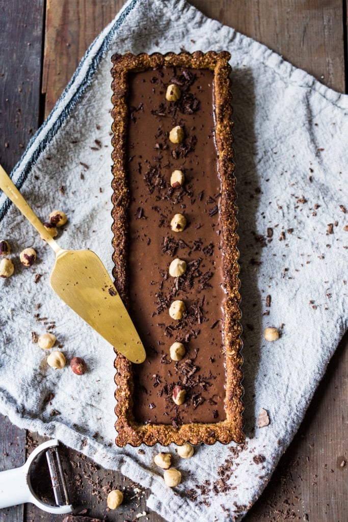 Chocolate Tart with Hazelnut Crust- a vegan and gluten-free tart that is deceptively decadent, silky smooth and luscious! | #vegantart #vegandessert #glutenfreedessert #hazelnuts #chololatetart www.feastingathome.com