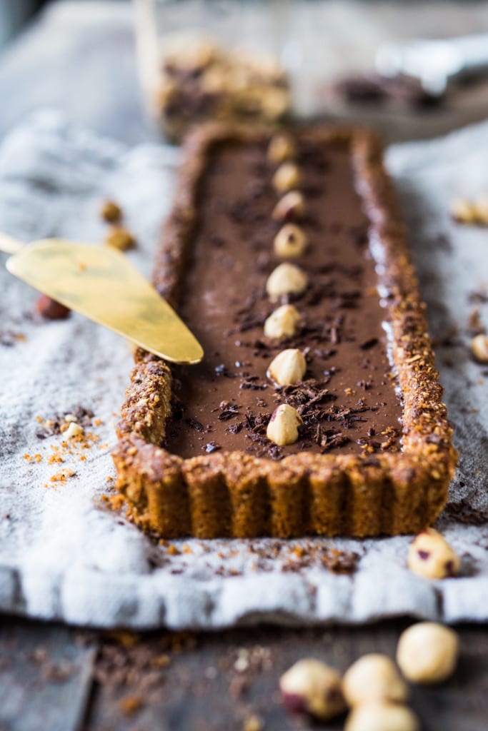 Vegan Chocolate Tart with Hazelnut Crust- a vegan and gluten-free tart that is deceptively decadent, silky smooth and luscious! | #vegantart #vegandessert #glutenfreedessert #hazelnuts #chololatetart www.feastingathome.com