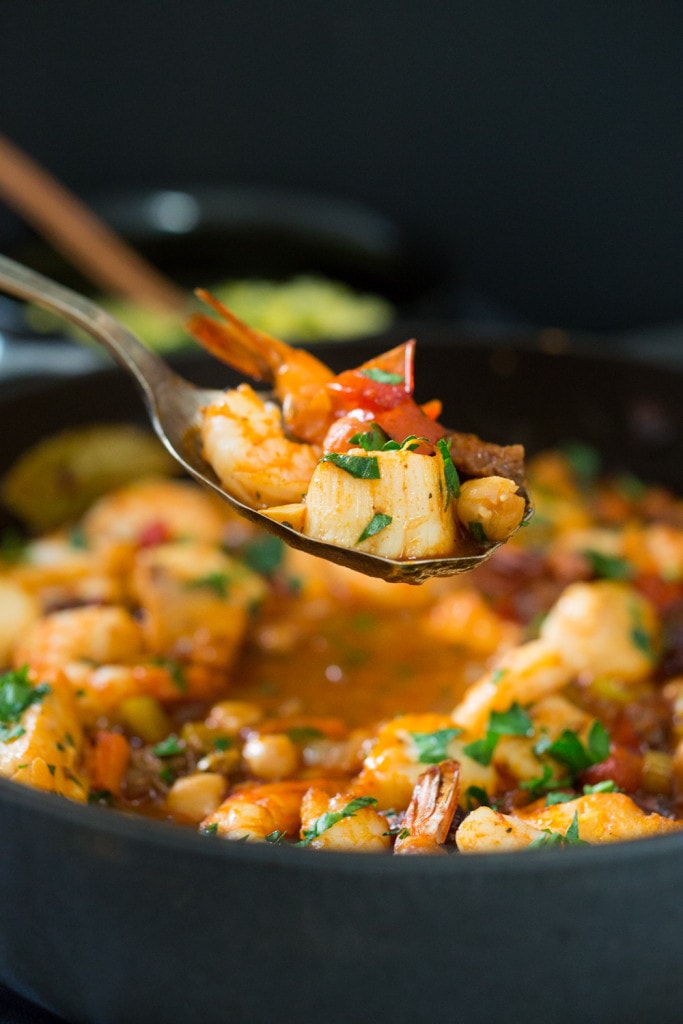 A simple delicious recipe for Spanish Seafood Stew with Garbanzo beans and Chorizo ( or soy Chorizo) served over Jasmine infused rice. | www.feastingathome.com