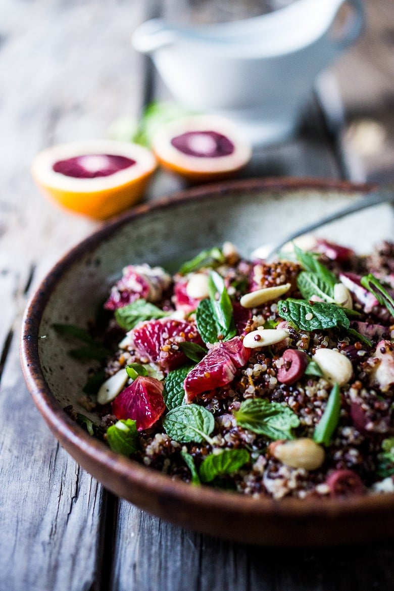 A delicious vegan Moroccan Salad with blood oranges, quinoa, almonds, olives, mint and a tangy, bright blood orange dressing. Perfect for the holiday table, this salad is festive and healthy! | #moroccansalad #bloodorange #bloodorangesalad #quinoasalad #vegansalad #holidaysalad #vegan #healthysalad www.feastingathome.com