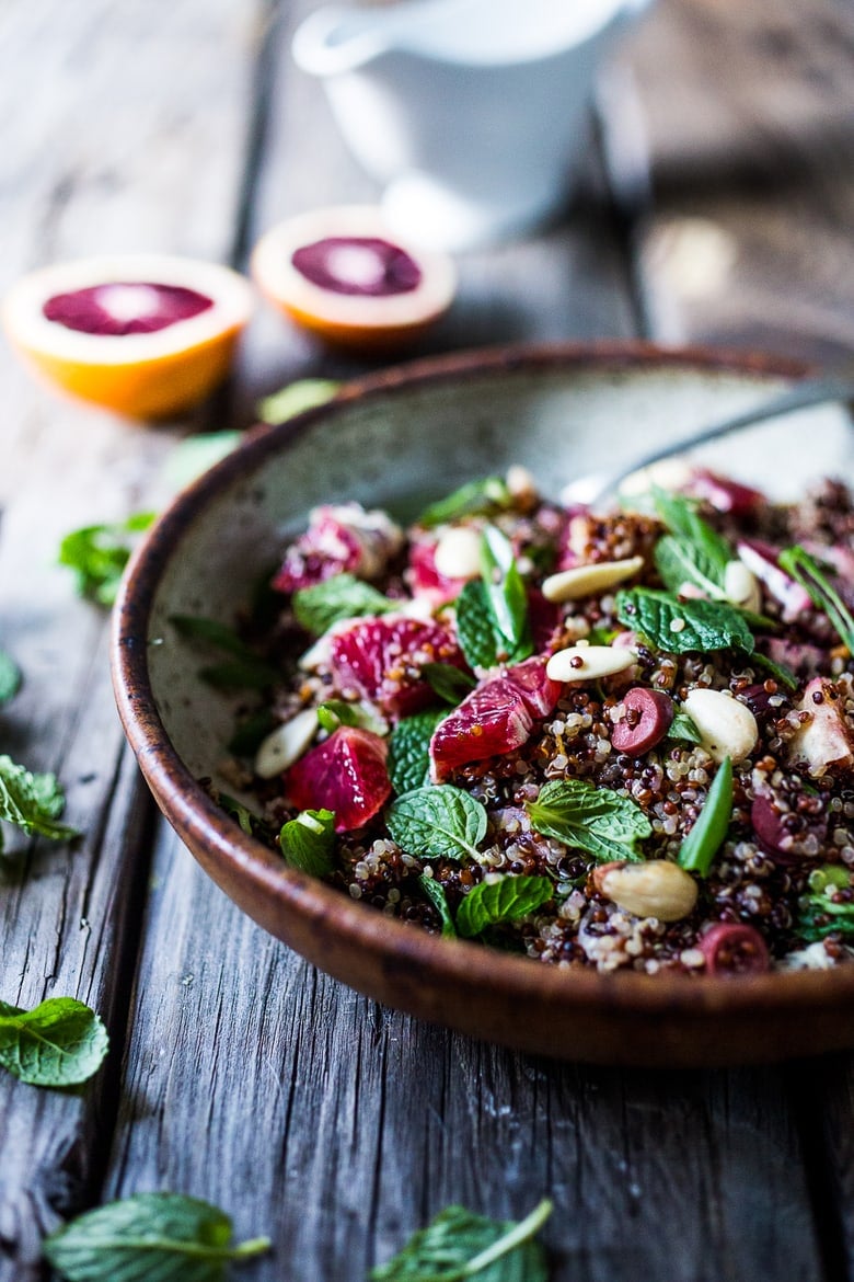 A delicious vegan Moroccan Salad with blood oranges, quinoa, almonds, olives, mint and a tangy, bright blood orange dressing. Perfect for the holiday table, this salad is festive and healthy! | #moroccansalad #bloodorange #bloodorangesalad #quinoasalad #vegansalad #holidaysalad #vegan #healthysalad www.feastingathome.com