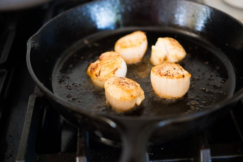 Seared Scallops with fragrant coconut lemongrass sauce, fresh basil and lime zest. FAST, Flavorful and easy to make. A Fresh and healthy recipe! | www.feastingathome.com