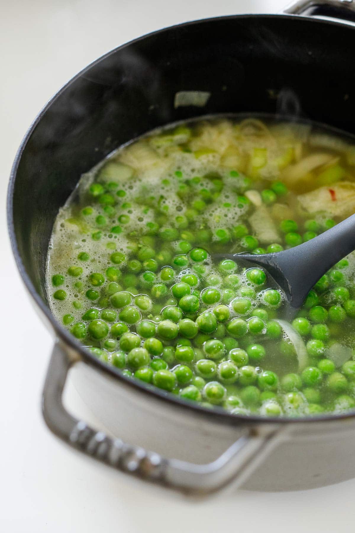 fresh peas added to soup pot to simmer.
