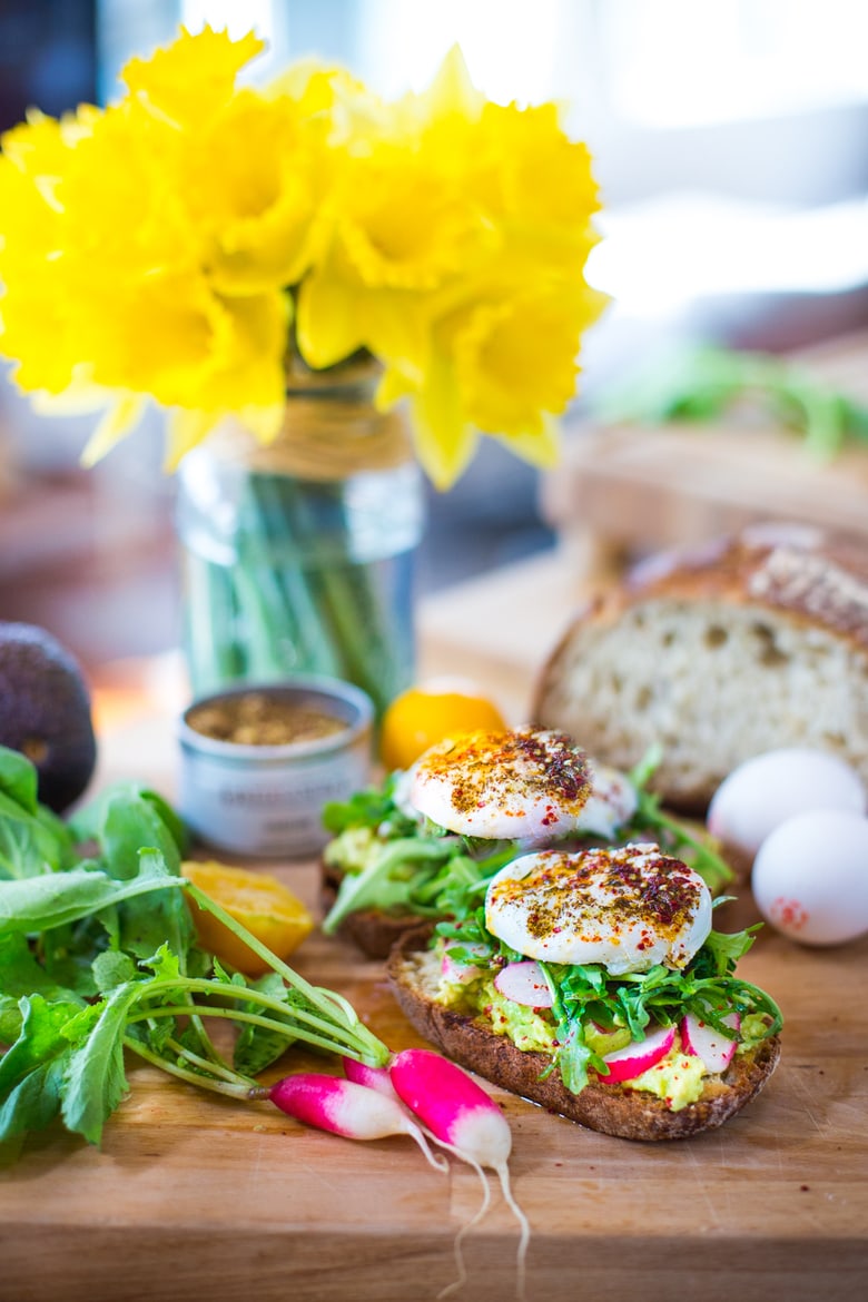 A simple tasty recipe for Avocado Toast with Poached Eggs, arugula, zaatar, lemon and radishes. Quick and delicious ...and healthy! | www.feastingathome.com