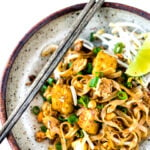 The Best 15 MINUTE PAD THAI- an easy, authentic recipe with made with accessible ingredients that can be made with chicken or tofu! Gluten free, Vegan adaptable with Incredible flavor ! | #authenticpadthai #easypadthai #padthai #padthainoodles www.feastingathome.com