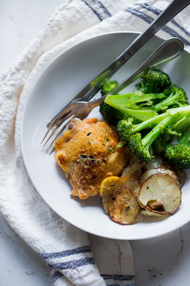 Roasted Chicken Thighs with Lemon, Thyme and Crispy Potatoes. An easy flavorful dinner with just 10 minutes of prep time, before baking in the oven. 