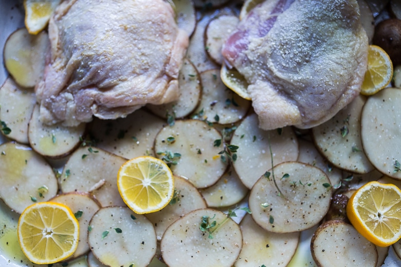 An EASY delicious recipe for One-Pan Chicken and Crispy Potatoes infused with fresh thyme, lemon, and garlic. 10 minutes of prep, then just bake! | www.feastingathome.com