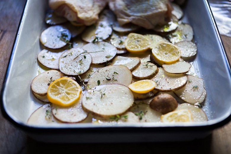 An EASY delicious recipe for One-Pan Chicken and Crispy Potatoes infused with fresh thyme, lemon, and garlic. 10 minutes of prep, then just bake! | www.feastingathome.com