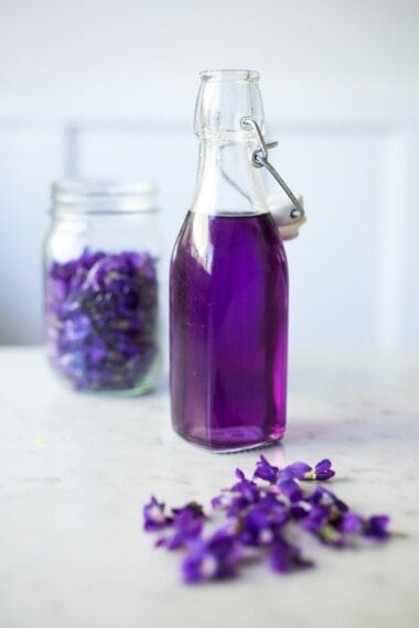 An easy recipe for Violet Simple Syrup- lovely in cocktails like a Violet infused French 75 - perfect for Mothers Day, Bridal Showers or Weddings. Romantic, floral, feminine. | www.feastingathome.com