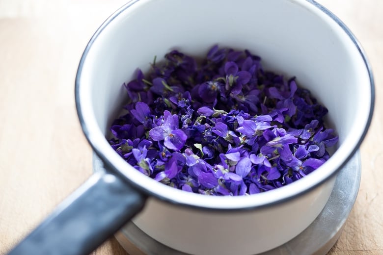 An easy recipe for Violet Simple Syrup- lovely in cocktails like a Violet infused French 75 - perfect for Mothers Day, Bridal Showers or Weddings. Romantic, floral, feminine. | www.feastingathome.com