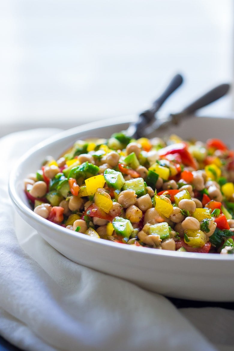 A simple & delicious recipe for Balela Salad, made w/ finely chopped vegetables, chickpeas, fresh herbs, lemon & olive oil. Serve in a pita with tahini sauce or over greens. | www.feastingathome.com