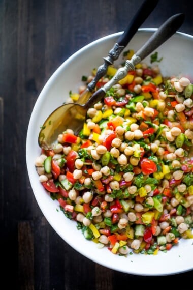 This Middle Eastern Chickpea Salad called Balela Salad, is vegan and healthy! Made w/ finely chopped veggies, fresh herbs, lemon & olive oil. Serve it in a pita with tahini sauce or over greens. | www.feastingathome.com #chickpeasalad #veganchickpeasalad #balela #balelasalad