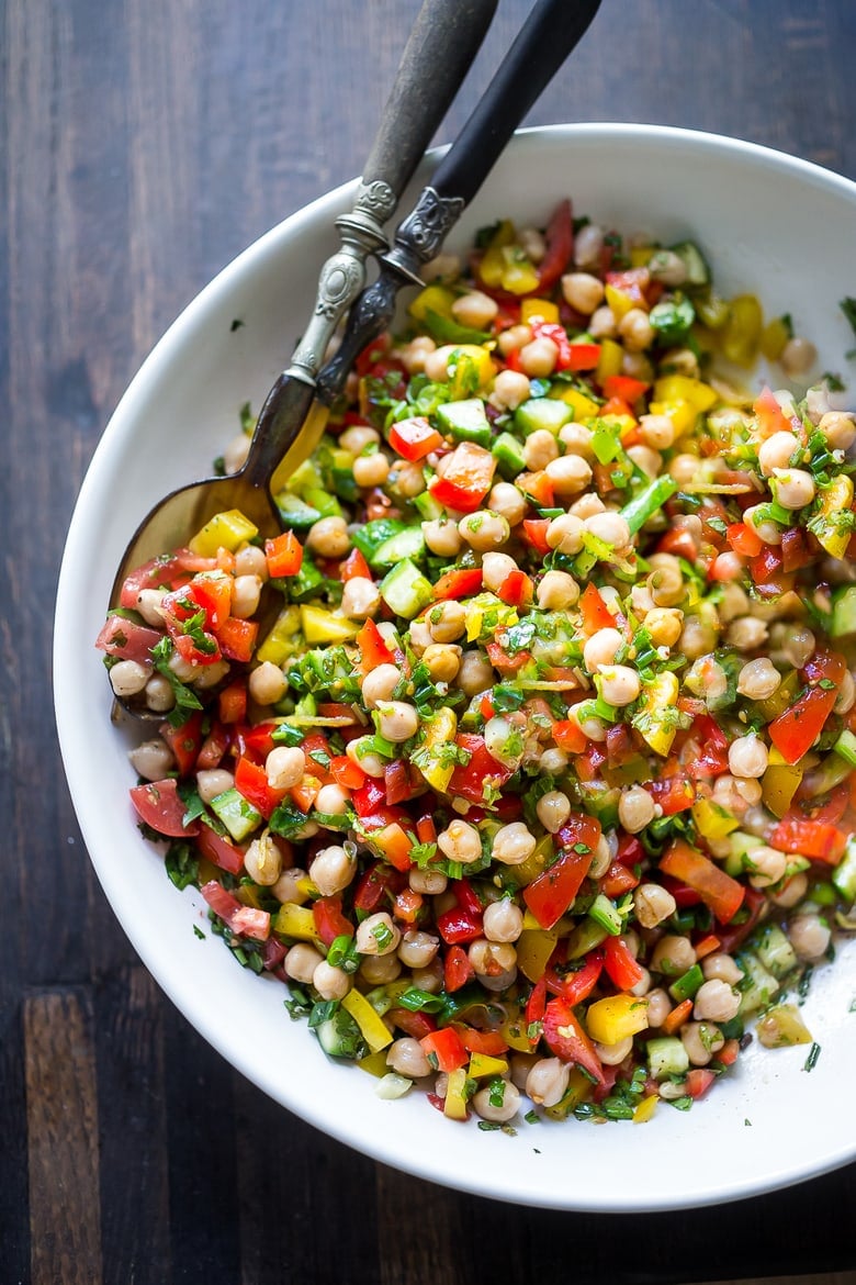 This Middle Eastern Chickpea Salad called Balela Salad, is vegan and healthy! Made w/ finely chopped veggies, fresh herbs, lemon & olive oil. Serve it in a pita with tahini sauce or over greens. | www.feastingathome.com #chickpeasalad #veganchickpeasalad #balela #balelasalad 