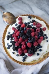 Simple and delicious Summer Berry Tart with a Short Bread Crust that requires no rolling, simply press it into the tart pan and bake. Refreshing and light, this recipe is a snap to make! | www.feastingathome.com