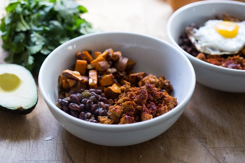 Healthy Yummy Breakfast Bowls with sweet potatoes, blackbeans, turkey chorizo ( optional) avocado, cilantro and and egg. | www.feastingathome.com