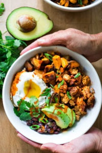 Healthy Yummy Breakfast Bowls with sweet potatoes, blackbeans, turkey chorizo ( optional) avocado, cilantro and an egg. | www.feastingathome.com