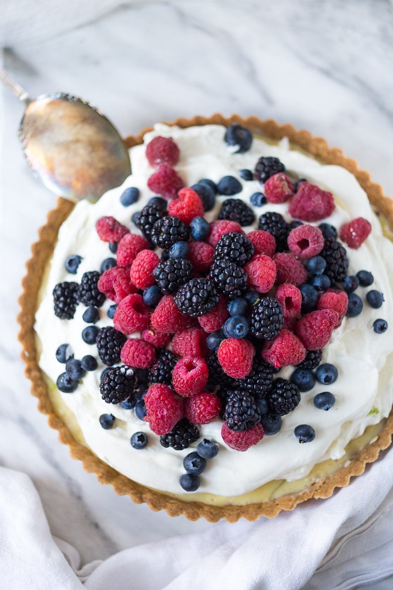 Simple and delicious Summer Berry Tart with a Short Bread Crust that requires no rolling, simply press it into the tart pan and bake. Refreshing and light, this recipe is a snap to make! | www.feastingathome.com
