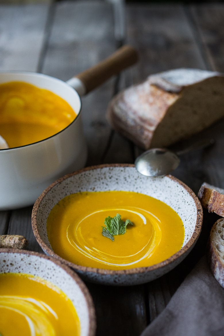 A delicious, healthy recipe for Glowing Carrot Turmeric Soup with Coconut Milk and ginger. Fresh turmeric and mint gives this soup its exotic flavor. Vegan. | www.feastingathome.com