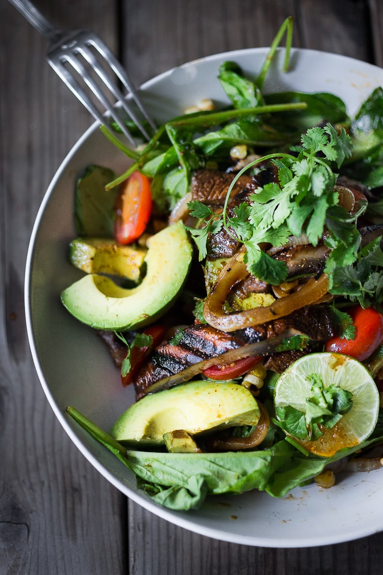 A simple tasty recipe for Grilled Portobello Steak Salad with avocado, lime, grilled sweet onions, grilled corn, tomatoes and a Smokey Lime Dressing. Vegan and Gluten Free! | www.feastingathome.com