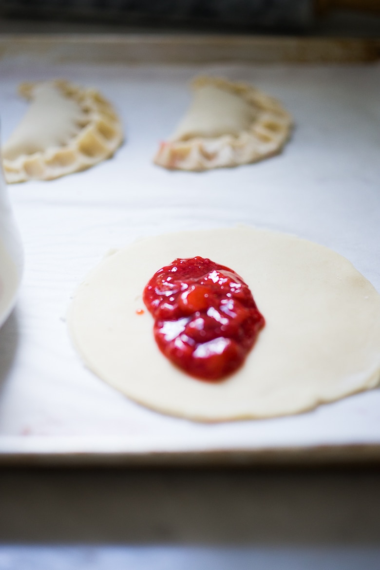 A simple delicious recipe for Strawberry Turnovers or "Hand Pies" , sweetened with maple syrup. Step by step instructions on mastering the "double fold" which prevent the filling from oozing out while baking. | www.feastingathome.com