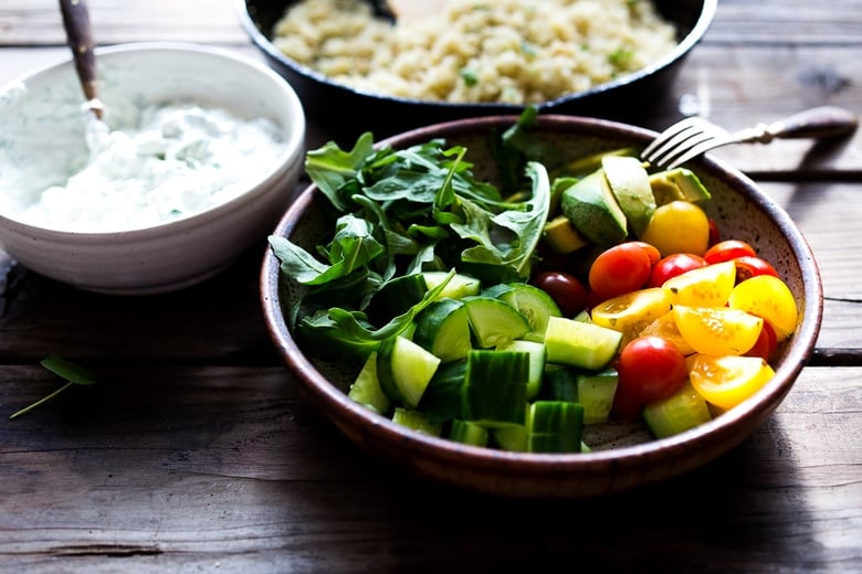 A simple tasty recipe for Grilled Greek Souvlaki Bowl with Cauliflower Rice, flavorful Cucumber Yogurt Sauce and fresh summer vegetables. This can be made with Grilled Chicken or Grilled Portobellos! | www.feastingathome.com