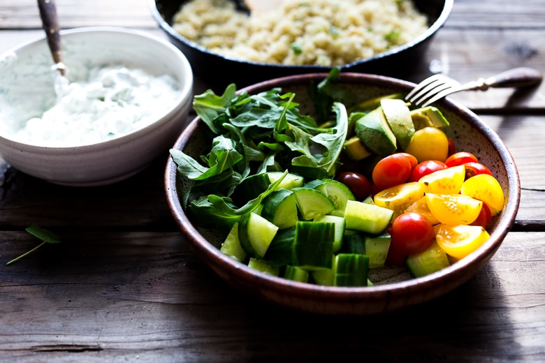 A simple tasty recipe for Grilled Greek Souvlaki Bowl with Cauliflower Rice, flavorful Cucumber Yogurt Sauce and fresh summer vegetables. This can be made with Grilled Chicken or Grilled Portobellos! | www.feastingathome.com