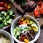 A simple tasty recipe for Grilled Greek Souvlaki Bowl with Cauliflower Rice, flavorful Cucumber Yogurt Sauce and fresh summer vegetables. This can be made with Grilled Chicken or Grilled Portobellos! | www.feastingathome.com