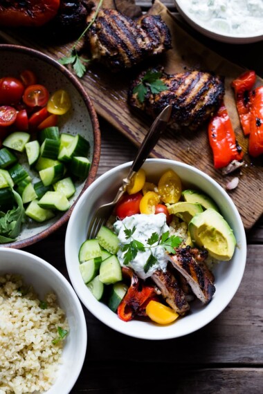A simple tasty recipe for Grilled Greek Souvlaki Bowl with Cauliflower Rice, flavorful Cucumber Yogurt Sauce and fresh summer vegetables. This can be made with Grilled Chicken or Grilled Portobellos! | www.feastingathome.com