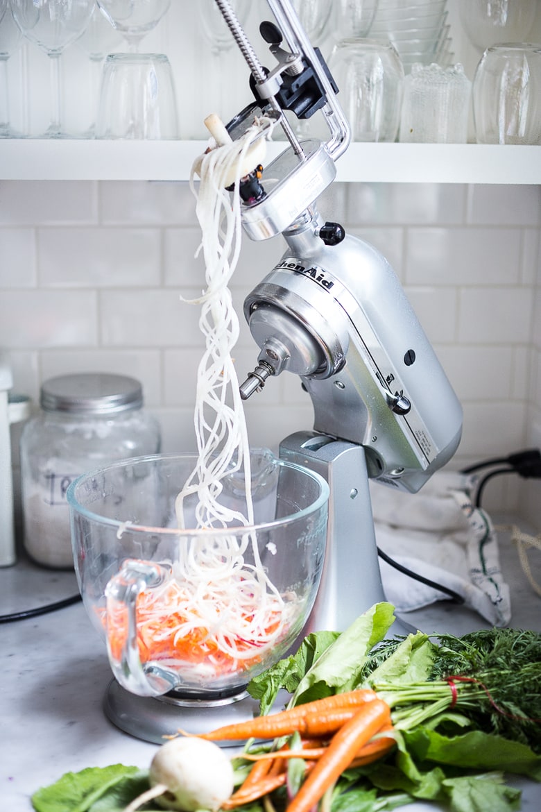 A simple tasty recipe for Tangled Summer Roots- spiralized kohlrabi, beets, turnips, radishes and carrots tossed with a yogurt garlic scape dressing. | www.feastingathome.com