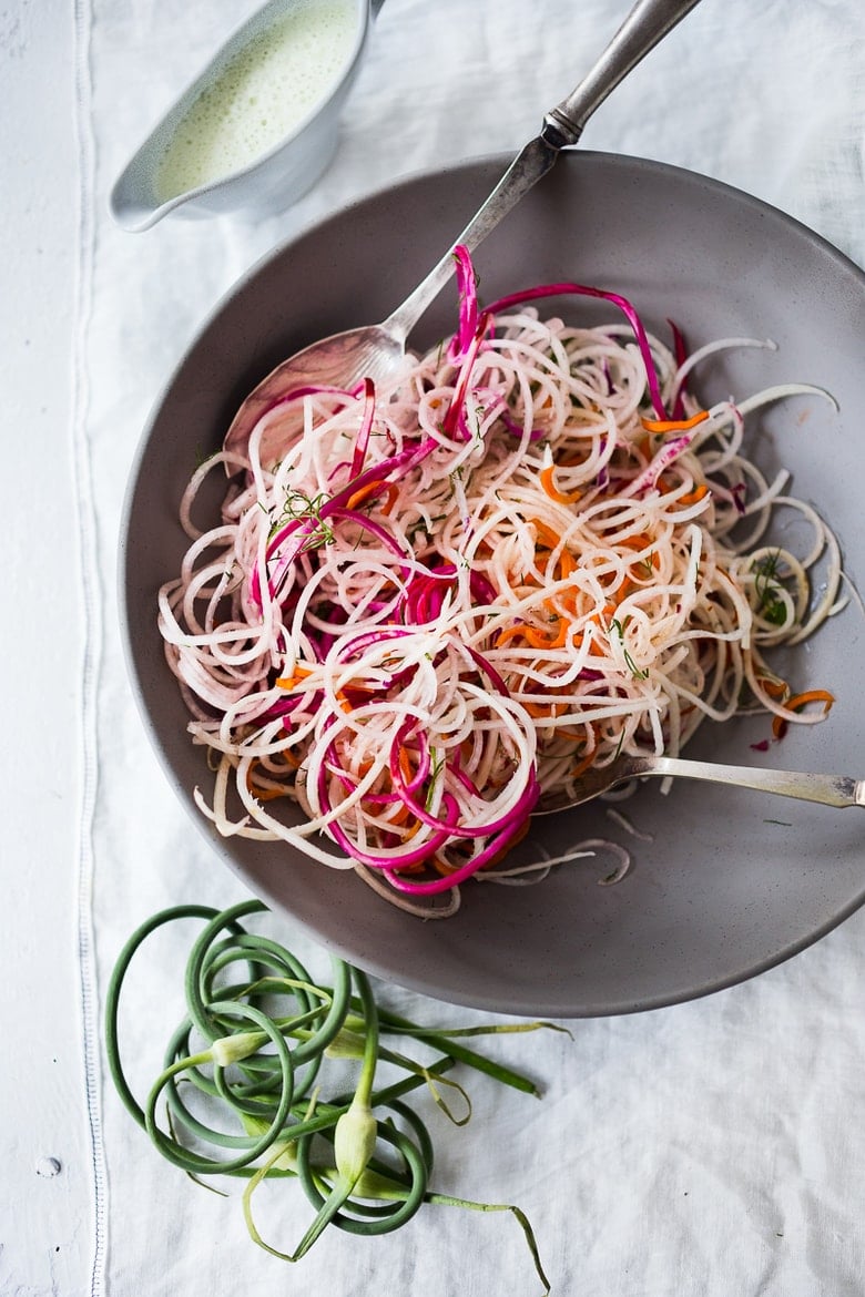 A simple tasty recipe for Tangled Summer Roots- spiralized beets, turnips, radishes and carrots tossed with a yogurt garlic scape dressing. | www.feastingathome.com