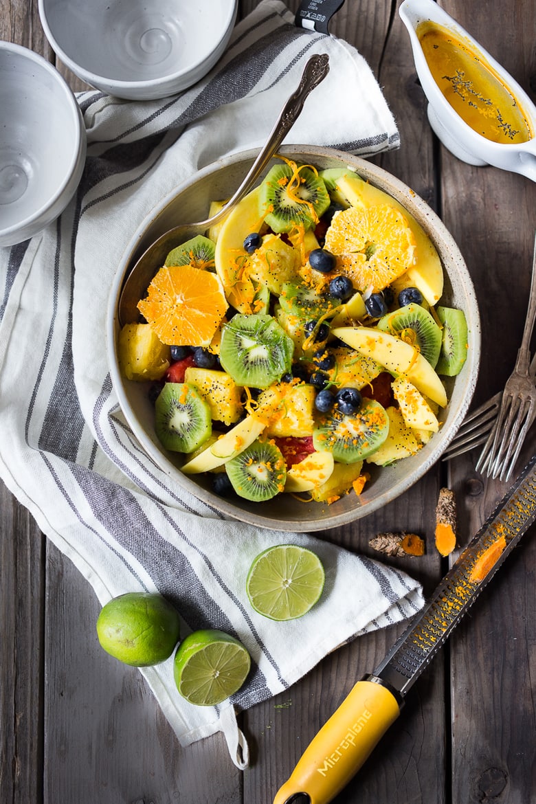 Exotic Turmeric Fruit Salad with fresh grated turmeric root, orange and lime zest and your favorite fruits, topped w/ toasted coconut flakes. Sugar free. | www.feastingathome.com