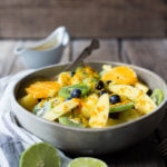 A tropical fruit salad with fresh fruit and berries, seasoned with fresh grated turmeric root, citrus juice and toasted coconut.