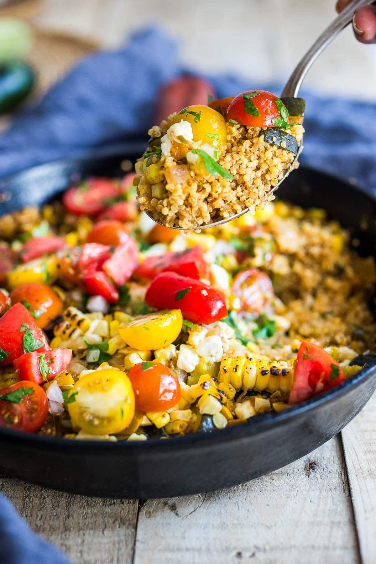 This easy Baked Quinoa is a hearty one-pan vegetarian dinner with zucchini, corn, melty cheese, and fresh tomato relish. No need to cook the quinoa first!